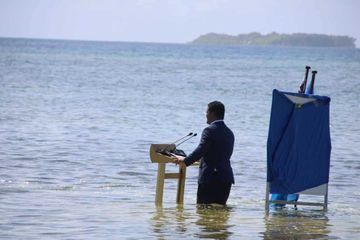 Les jambes dans l'eau, un ministre des Tuvalu lance un avertissement au monde