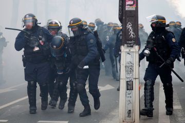 Des CRS accompagnent l'un de leurs collègues blessé, mardi lors de la manifestation des pompiers à Paris.