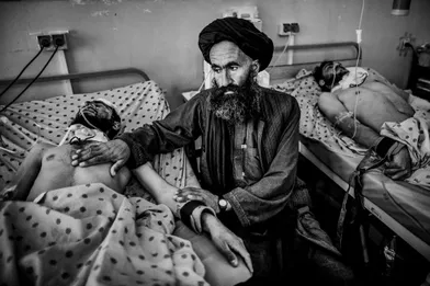 An Afghan man sitting beside his injured son by Taliban attack in Kandahar, treated in Mirvays Hospital after killing of Bin laden, in Pakistan,it was the most serious attack by his supporters lead to 4 killed and 36 injured.
