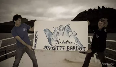 Le logo de la Fondation BB revisité pour l'occasion, et tenu par Christophe Marie (gauche) et Howie, co-fondateur de l'association Surfer for cetaceans.