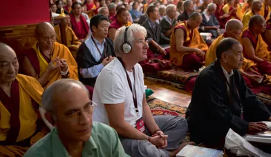 Pendant les commentaires du Lamrim, casque pour traduction simultanée sur les oreilles, l’acteur Richard Gere, disciple assidu du dalaï-lama depuis des années.