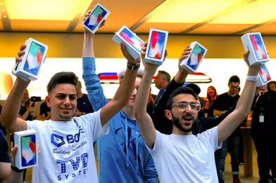 Victorieux, deux des premiers clients de cet Apple Store de Sydney, en Australie, brandissent leurs iPhone X, vendredi.