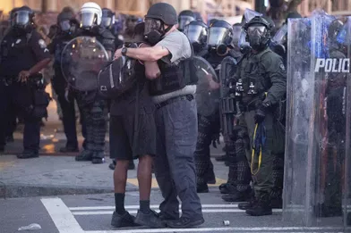 Un officier prend un manifestant dans ses bras àAtlanta