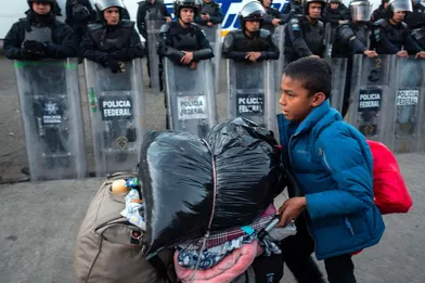 Un enfant, qui a marché parmi une des «caravanes» de migrants, avance devant les policiers mexicains à Tijuana, en janvier 2019.
