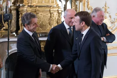 Emmanuel Macron serre la main à Nicolas Sarkozy.