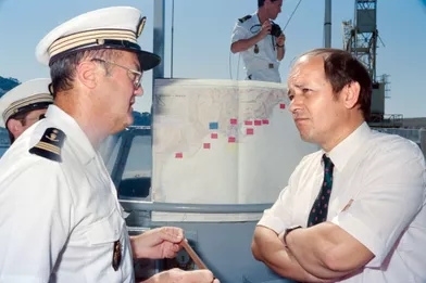 Le secrétaire d'état à la mer Jean-Yves Le Drian (D) discute avec un membre de la police maritime chargé du contrôle des plaisanciers, le 3 août 1991.
