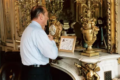 5 mai 2002.Jacques Chirac dans son bureau de l'Elysée le jour du deuxième tour des élections présidentielles 2002 : de trois-quart dos, vérifiant son noeud de cravate devant le miroir. Sur la cheminée, dans le cadre, des dessins de son petit-fils Martin.