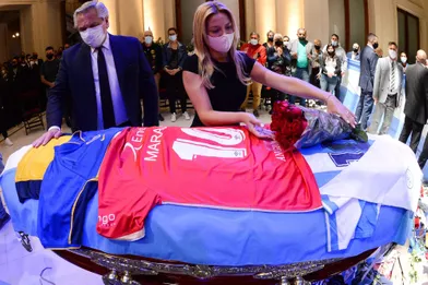 La première dame argentine Fabiola Yanez dépose des fleurs sur le cercueil de la légende du football Diego Maradona sous le regard du président argentin Alberto Fernandez, au palais présidentiel Casa Rosada, à Buenos Aires.