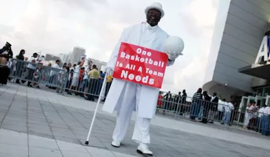 Un supporter aux couleurs de l'équipe de Miami maintient une pancarte &quot;Un ballon de basket, c'est tout ce dont a besoin une équipe&quot;.