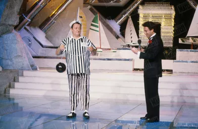 Coluche aux côtés de Michel Drucker, sur le plateau de l'émission &quot;Champs-Élysées&quot;, en juillet 1985.