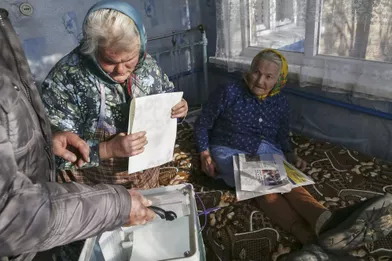 Un membre de la commission électorale rassemble dans une urne mobile les votes des habitants du village deHavronshchyna près de Kiev.