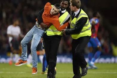 Un fan de Crystal Palace est appréhendé par la sécurité lors d'un match de Premier League qui oppose son équipe favorite à Liverpool, à Londres.