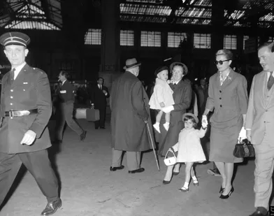 Grace de Monaco tient sa fille Caroline par la main, tandis que le nanny anglaise Mlle King porte le petit Albert, à l'arrivée de la famille à la Gare de Lyon, à Paris, le 5 octobre 1959.