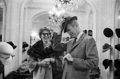 James Stewart essaie des chapeaux sous le regard amusé de son épouse Gloria, lors d’un passage à Paris en novembre 1959.