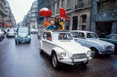Jacques Dutronc et trois jeunes filles à bord d'une Dyane Citroën décapotable, rue François 1er à Paris, pour le Salon de l'auto 1967.