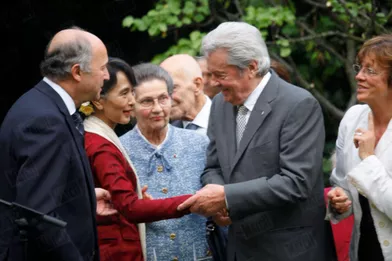 La députée birmane avec Laurent Fabius, alors ministre des Affaires étrangères, Simone Veil et Alain Delon, à Paris en juin 2012.