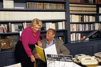 9 mai 1997. A Paris, chez eux, Christine GOUZE-RENAL, debout auprès de son mari Roger HANIN, à son bureau tenant le scénario de son film SOLEIL le clap du film posé au premier plan.