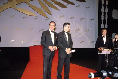 Festival Cannes 1991, l'immense Roger Moore remet le prix d'interprétation masculine àJohn Turturro,pour son rôle dans «Barton Fink» des frères Coen.