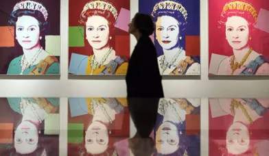 Une femme passe devant un tableau représentant la reine Elizabeth II. L’œuvre réalisée par Andy Warhol est exposée au &quot;National Portrait Gallery&quot; de Londres.