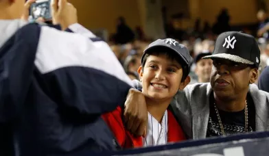 Le rappeur, et futur papa, Jay-Z pose avec un de ses fans, dans les gradins du match de baseball entre les Yankees de New York et les Tigers de Détroit.