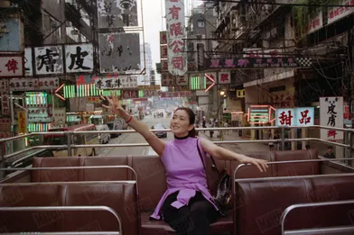 « En bus à impériale, comme à Londres, Gong Li rayonne dans le quartier populaire de Mongkok» - Paris Match n°2624, 9 septembre 1999