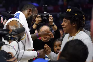 Jay-Z et sa fille Blue Ivy discutent avec LeBron Jameslors d'un match opposant les Lakers aux Clippers à Los Angeles le 8 mars 2020