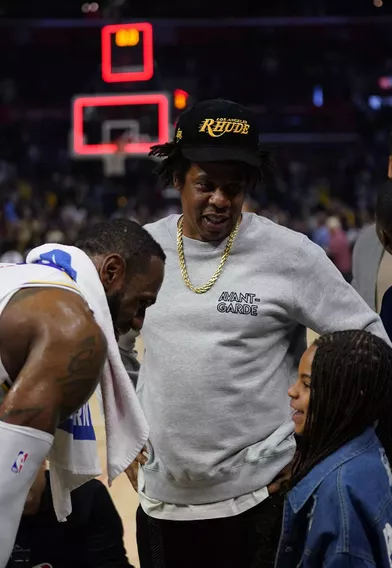 Jay-Z et sa fille Blue Ivy discutent avec LeBron Jameslors d'un match opposant les Lakers aux Clippers à Los Angeles le 8 mars 2020