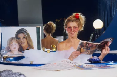 Sheila prend la pose dans son bain, à côté d'une photo de Ludovic, dans sa propriété de Neuilly, en 1982.