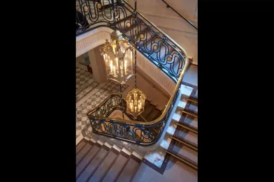 La cage d’escalier monumentale, classée, mène aux Salons historiques de l’étage noble, puis aux grands appartements signés Karl Lagerfeld.
