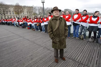 Le 28 novembre 2009, le président du Sidaction Pierre Bergé pose sur le pont des Arts,aux côtés de volontaires venus participer à une chaîne de solidarité.