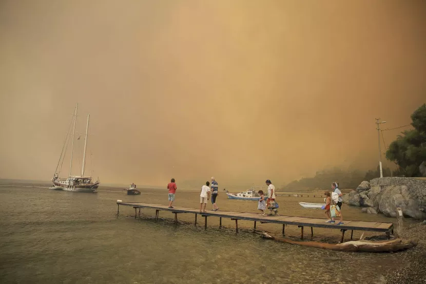 Des touristes attendent d’être évacués alors que le feu est sur le point d’atteindre le rivage, à Bodrum, en Turquie, le 1er août.