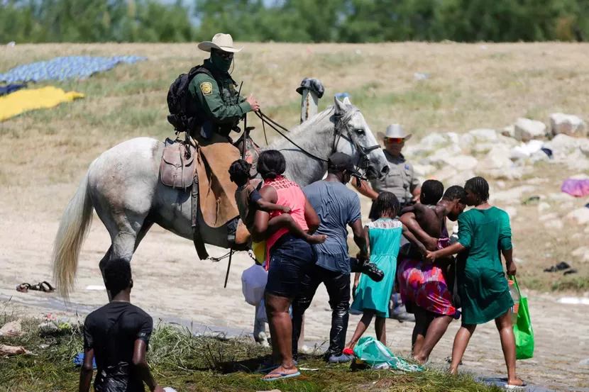 Un officier de la police aux frontières face à des migrants au bord du Rio Grande, entre Ciudad Acuña et Del Rio, le 19 septembre 2021.