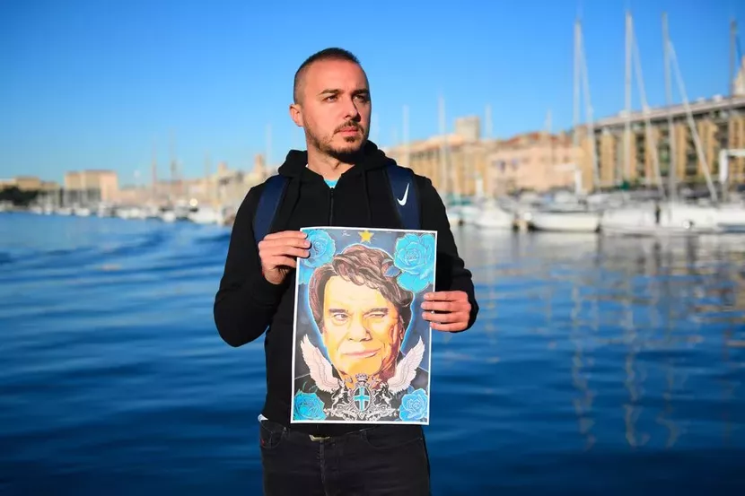 Un supporter de l'OM pose avec un portrait de Bernard Tapie.