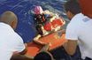 Capture d’image extraite d’une vidéo des  gardes-côtes italiens. A proximité de Lampedusa, des sauveteurs  en train d’aider des immigrants.