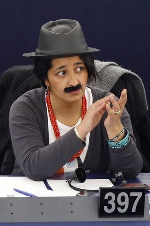 En 2011, Karima Delli porte un chapeau et une moustache dans l'hémicycle de Strasbourg lors de la journée de la femme.