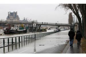  Des gens marchent sur les bords de Seine inondés.