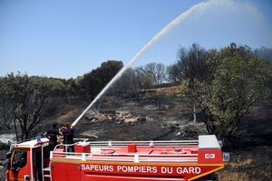 Les pompiers éteignent les derniers foyers d'un feu de broussailles dans la campagne autour de Saint-Gilles, dans le Gard, le 29 juin 2019.