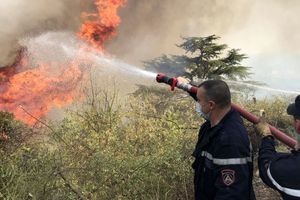 Des pompiers tentent d'éteindre les flammes d'un incendie de forêt dans le village de Tala N'tazert en Kabylie, Algérie, le 13 août 2021