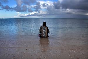 Une femme contemple son mari qui pèche au large des îles Kiribati (Pacifique central). Des atolls dangereusement menacés par la montée des eaux liée au réchauffement planétaire.