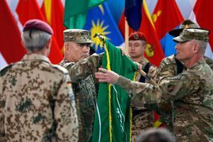 Le commandant de la force de l'Otan en Afghanistan (Isaf) le général américain John Campbell plie le drapeau de l'Isaf.