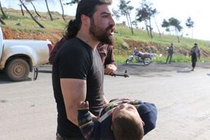 Abd Alkader Habak portant un petit garçon blessé dans l'attaque de samedi.