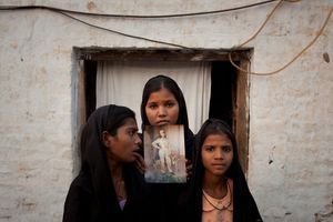 Les filles d'Asia Bibi (de gauche à droite : Esha, 12 ans, Sidra, 18 ans et Eshum, 10 ans) tenant une photo de leur mère, le 13 novembre 2010. 