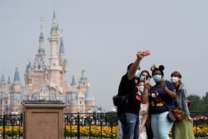 Des touristes devant le château à Disneyland en Chine. 