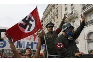  Des manifestants grecs ont défilé mardi à Athènes déguisés en soldats allemands de la Seconde Guerre mondiale et brandissant des drapeaux nazis pour dénoncer la venue de la chancelière allemande Angela Merkel, jugée en partie responsable de l'austérité instaurée dans le pays depuis deux ans