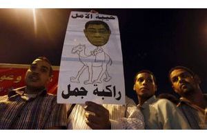  Des manifestants brandissent un dessin du procureur général Abdel Meguid Mahmoud et d'un chameau, pour dénoncer le pouvoir qu'ont encore certains caciques de l'ère Moubarak.