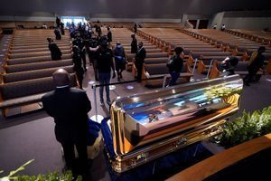 Des anonymes défilent à Houston devant le cercueil doré de George Floyd .