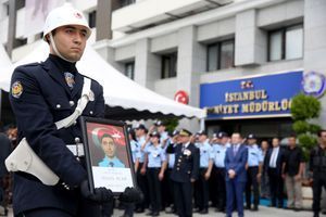 Un officier tient dans ses mains la photo de Sinan Acar. 