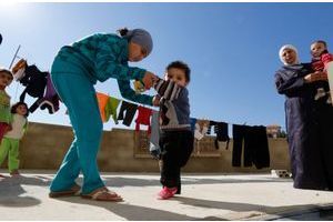 Un jeune réfugié syrien soupçonné d'avoir la polio aidé par sa soeur pour marcher, dans le camp de Chebaa, au Liban.