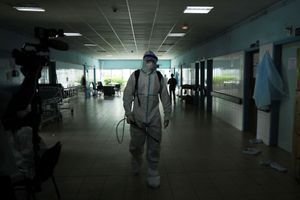Un agent de santé, portant une combinaison de protection et un masque facial, marche alors qu'il se prépare à désinfecter un couloir d'un hôpital après qu'un cas d'Ebola a été confirmé à Abidjan. 