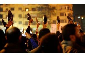  Les manifestants de la place Tahrir, ont brandi des chaussures afin de manifester leur mécontentement en entendant le discours du Raïs.